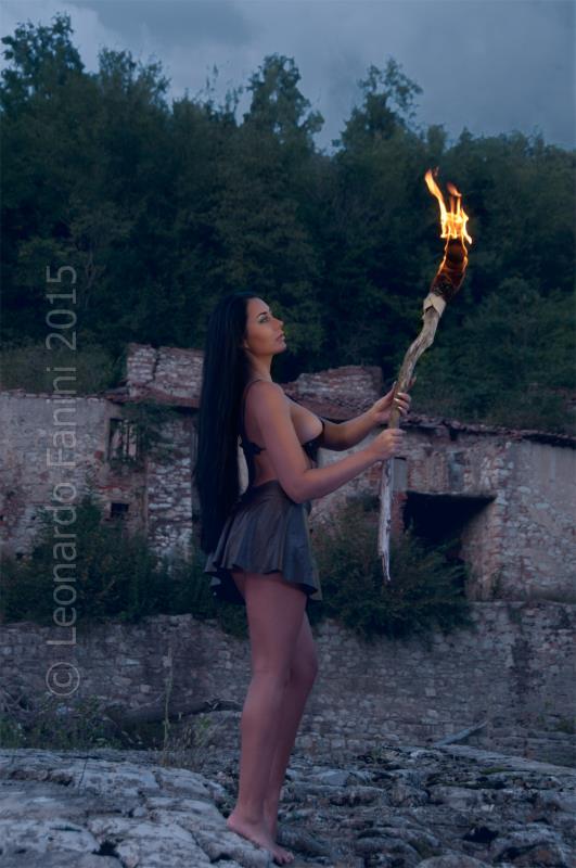 she stands watching her torch and showing the leather skirt I made