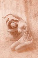 Sepia-toned artistic photograph of a woman in a flowing pose with her arms raised gracefully, evoking a sense of delicate movement.